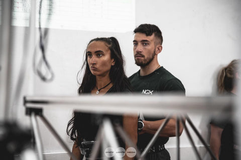 Man and women with a straight face. The women preparing for a weightlifting session.